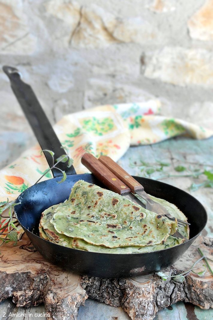 tagliere di olivo con padella in ferro con all'interno fregnacce di vitalba