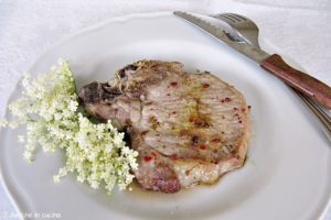 braciola di maiale al pepe rosa con fiori di sambuco freschi