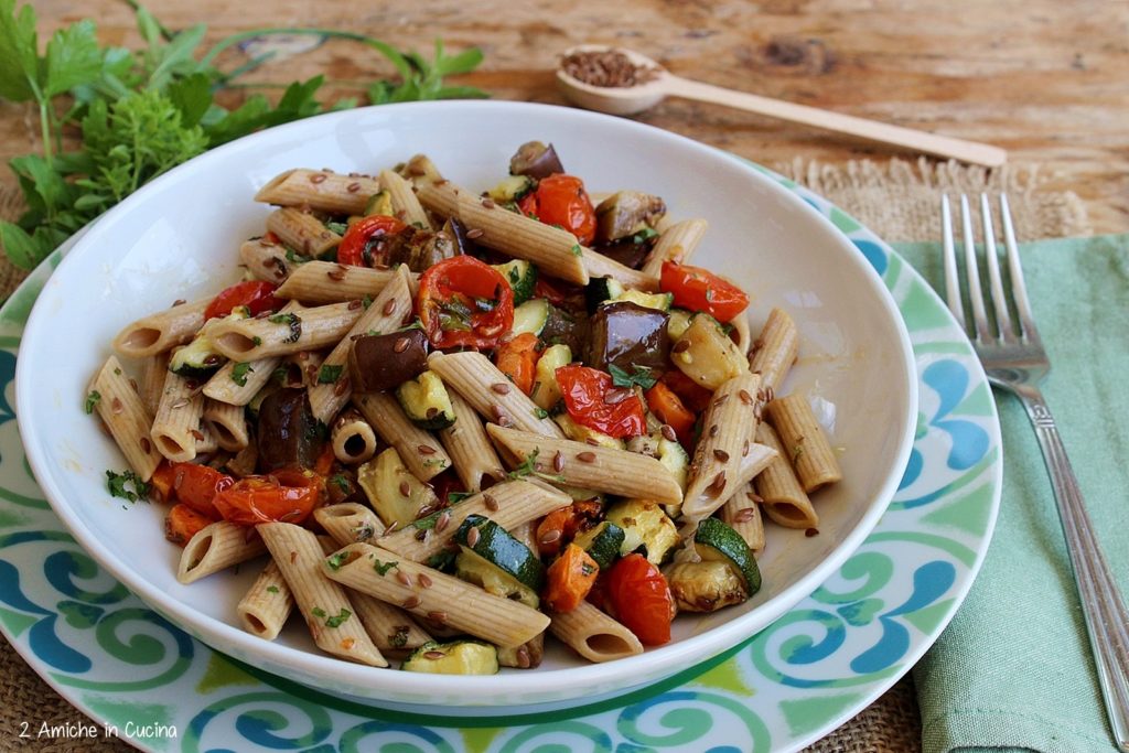 piatto di pasta con penne ai semi di lino condita con verdure estive