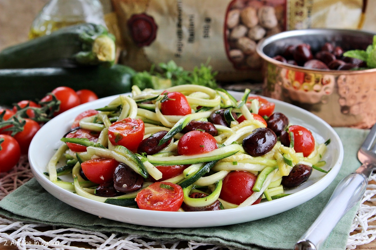 spaghetti di zucchine crude fagioli pomodori e aromatiche