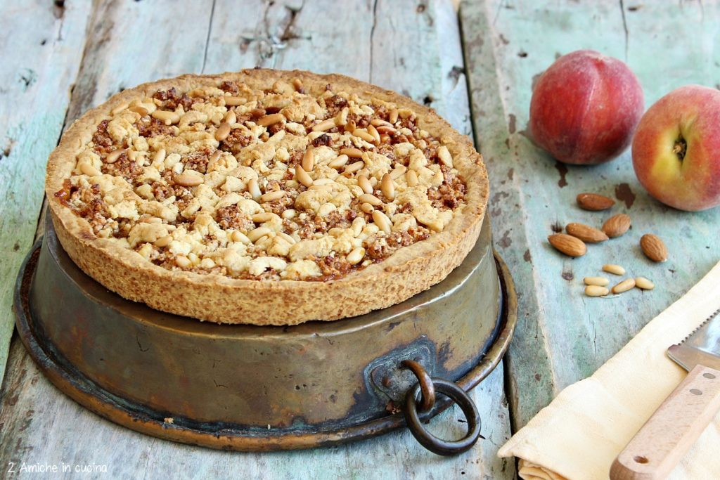 Crostata alle pesche con copertura alle mandorle e pinoli