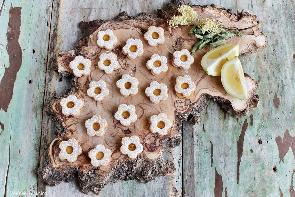 Fiorellini di frolla farciti con marmellata di limoni e fiori di sambuco.