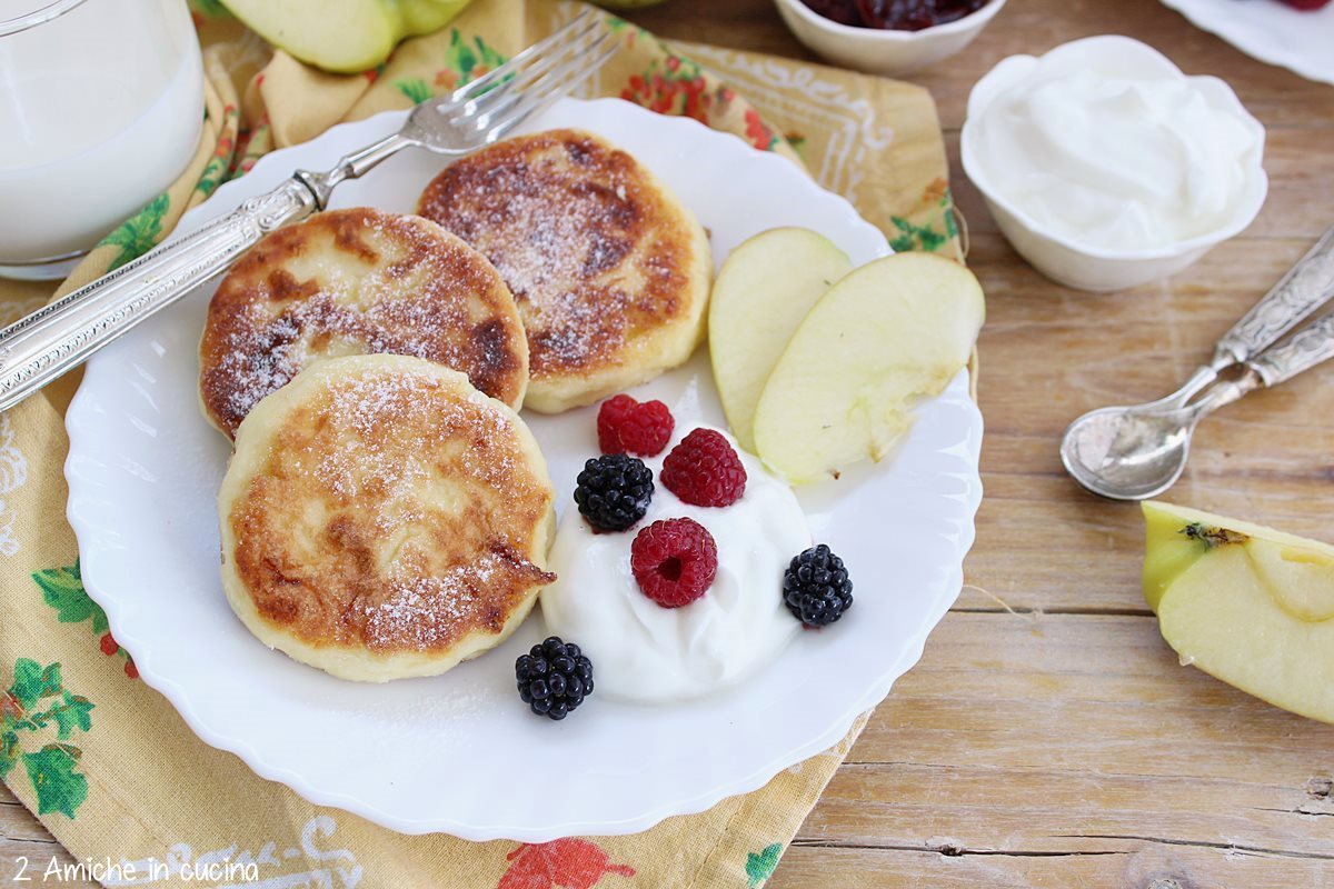 Syrniki russi di tvorog con mele e frutti rossi