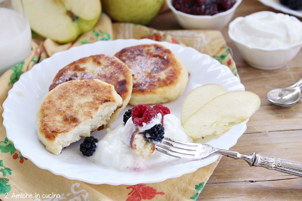 Frittelle russe con mele, panna acida e frutti rossi