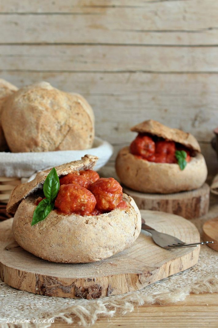 Pagnottine di pan ner piena di polpette al sugo con uvetta e pinoli