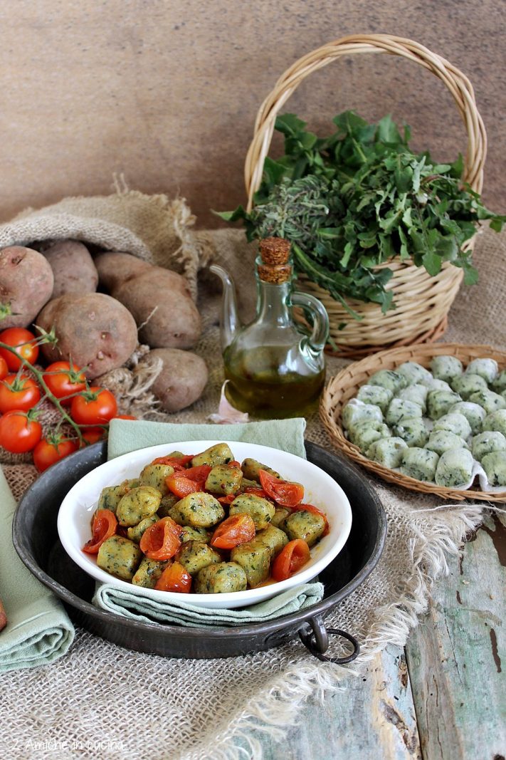 Piatto di gnocchi con cicoria conditi con pomodori freschi
