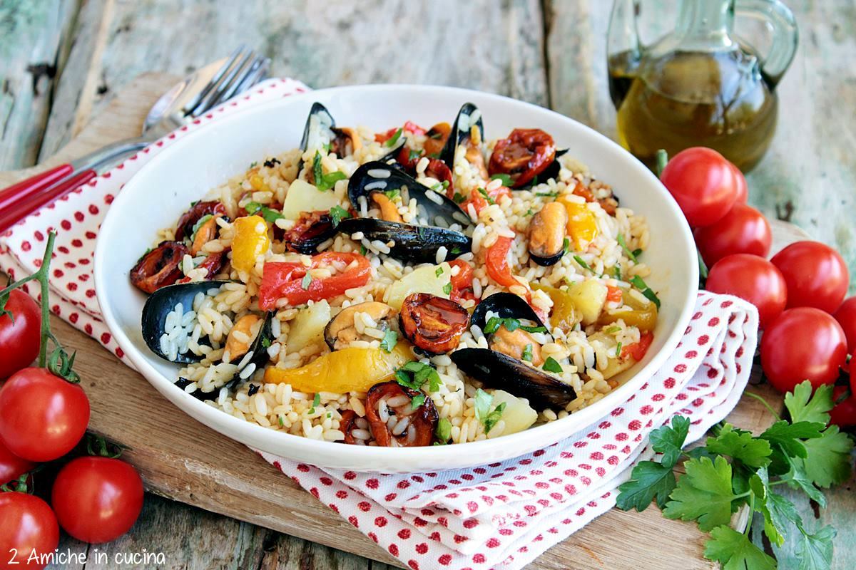 piatto bianco con insalata di riso con le cozze , le patate e i peperoni