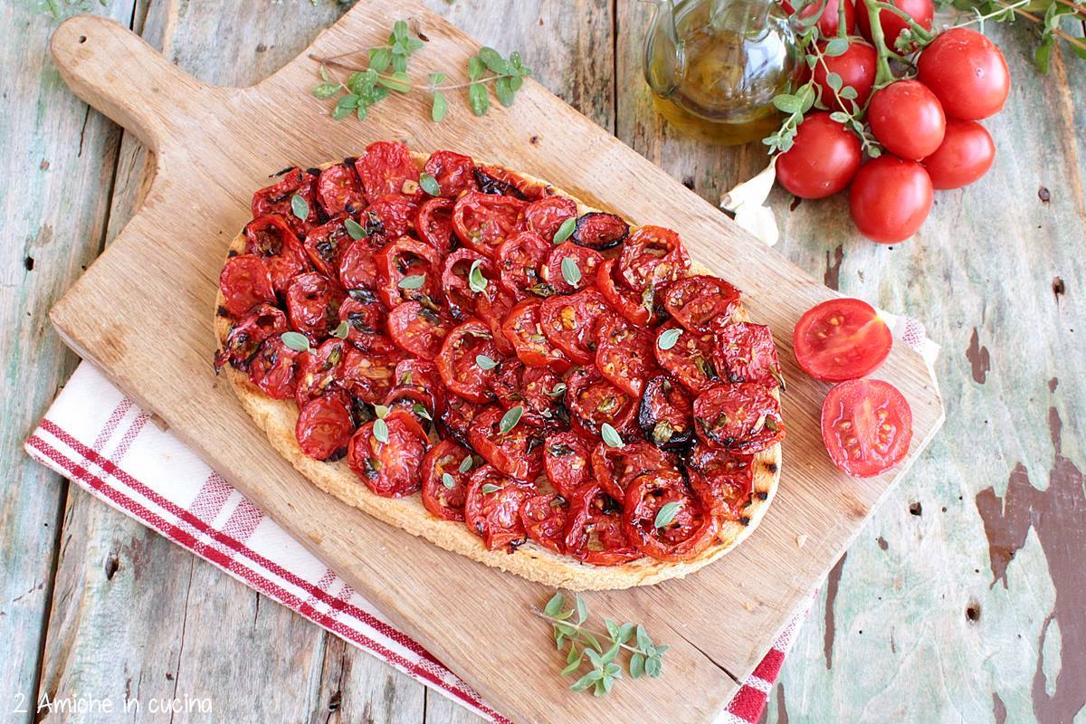 tagliere con bruschetta ai pomodori con aglio e foglioline di maggiorana