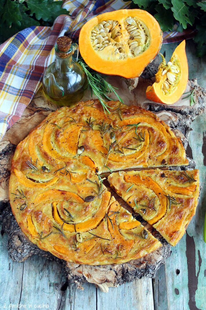 Farinata alla zucca e rosmarino con semi su tagliere con ilio di oliva e zucca Hokkaido