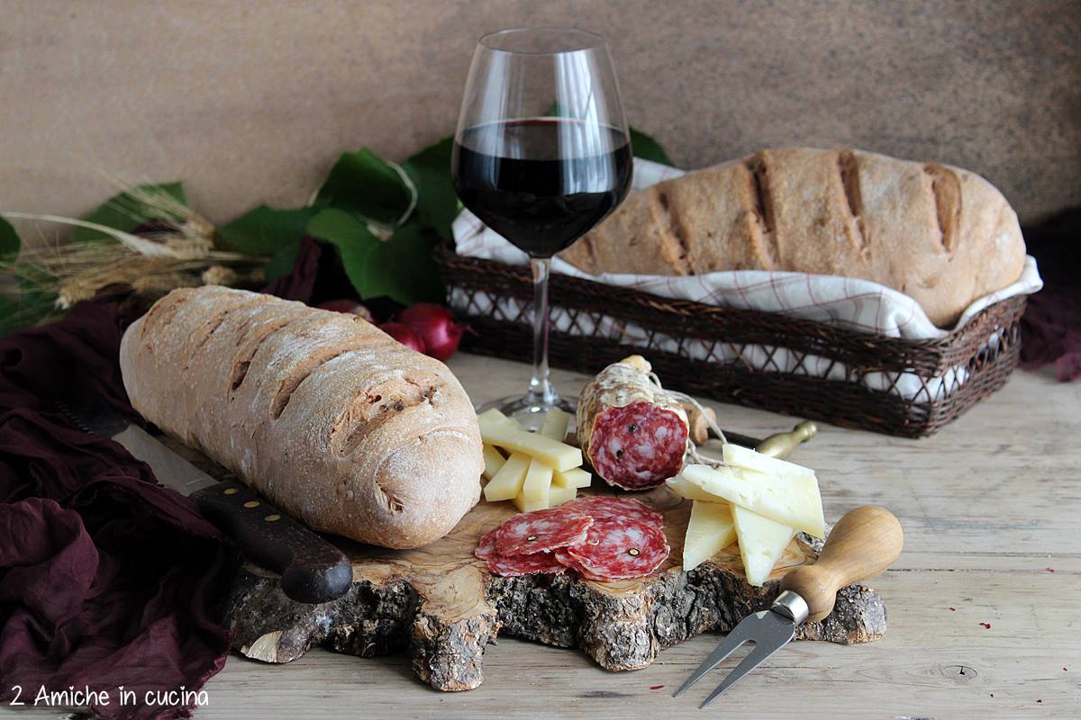 tagliere con pane al Sagrantino, formaggi, salame e calice di vino 