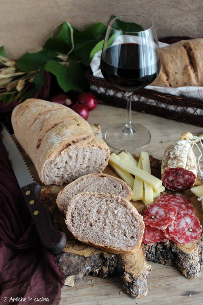 filone di pane al Sagrantino tagliato a fette con vino, salame e formaggio