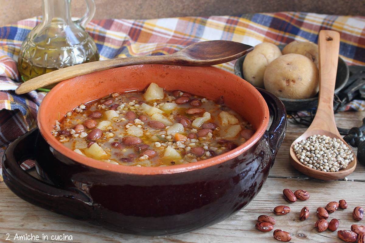 pentola in coccio con zuppa di sorgo, patate e fagioli