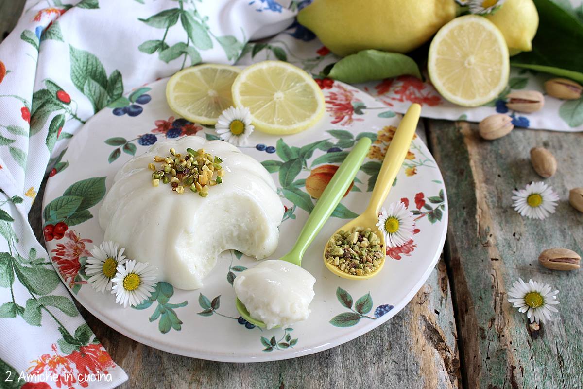biancomangiare al limone e pistacchio su piatto a fiori con fette di limone e margherite
