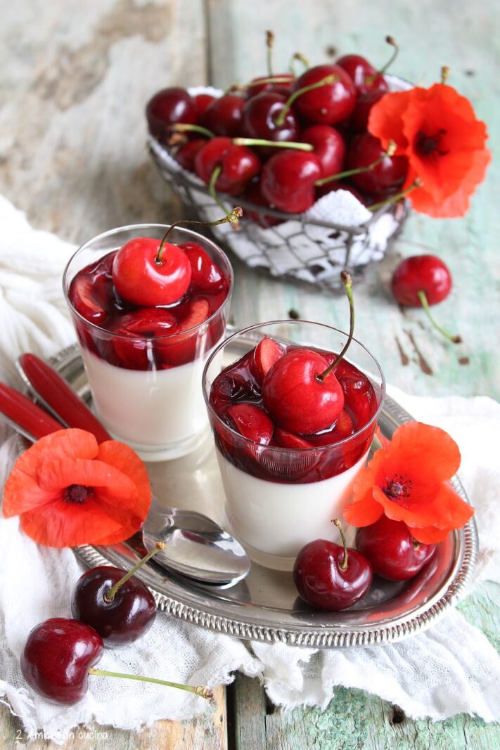 vassoio con bicchierini di panna cotta alle ciliegie e papaveri