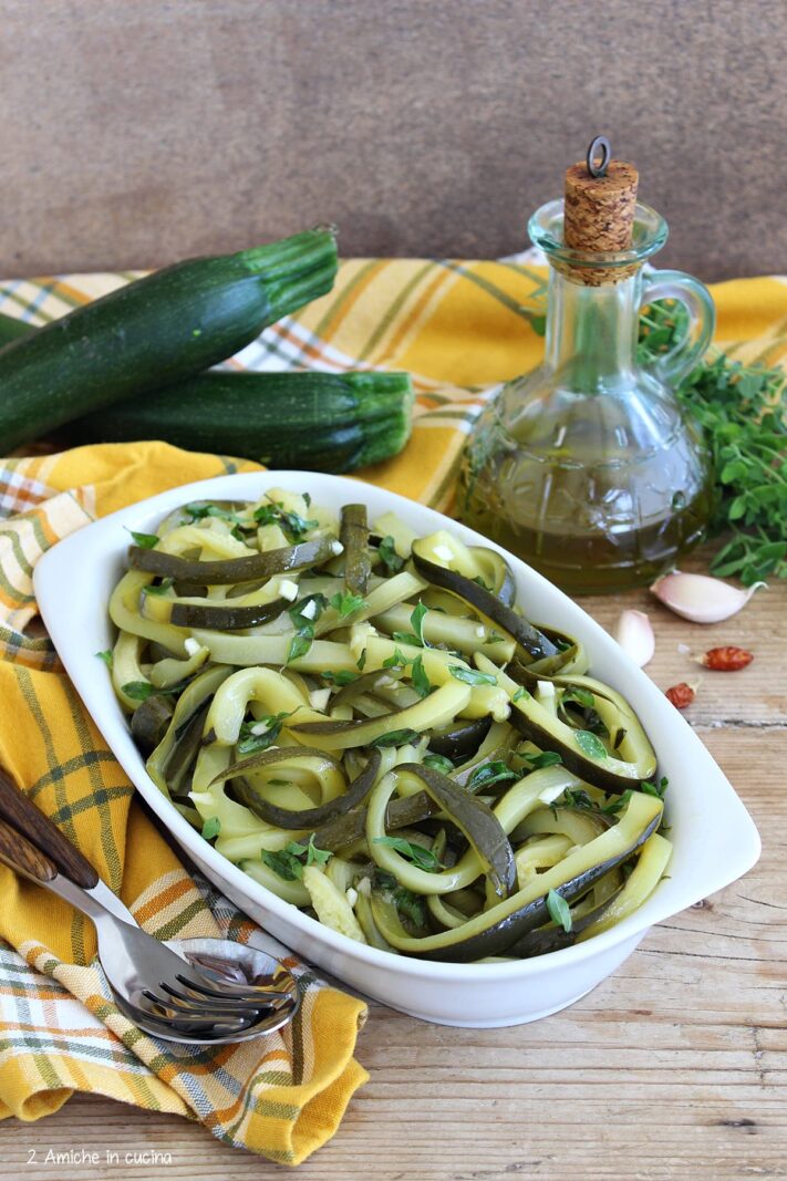 pirofila con zucchine, bottiglia di olio aglio e peperoncino