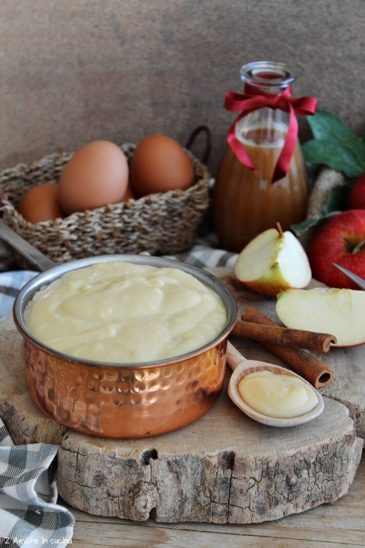 crema pasticcera alle mele nel pentolino di rame con stecca di cannella e mele gala