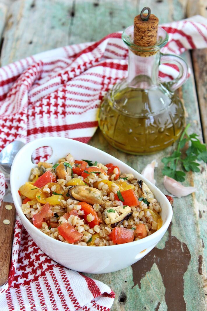 ciotola con insalata di farro e bottiglia di olio di oliva