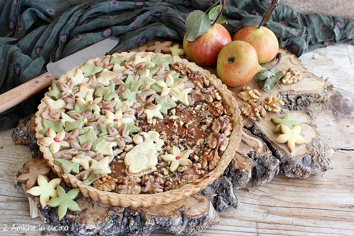 crostata alle pere decorata con foglie, fiori colorati e noci