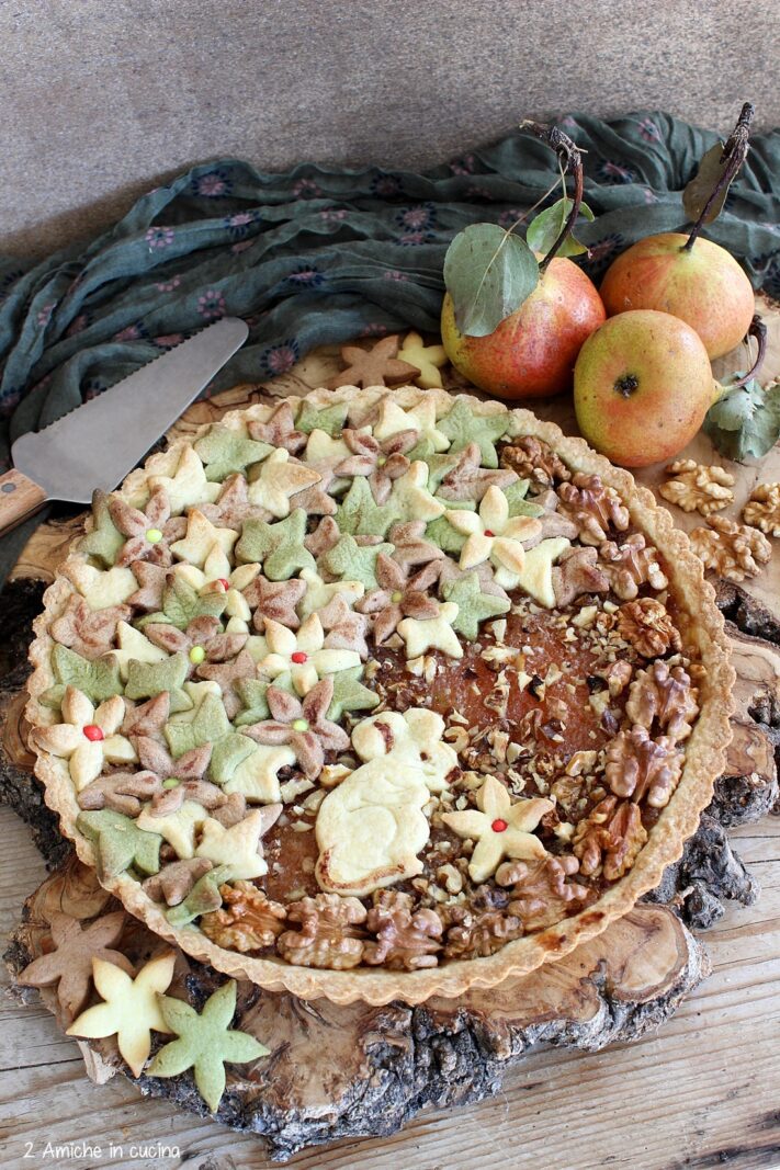 crostata decorata con foglie e fiori autunnali farcita con confettura di pere e noci